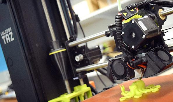 3D printer creating a bright green octopus figure.